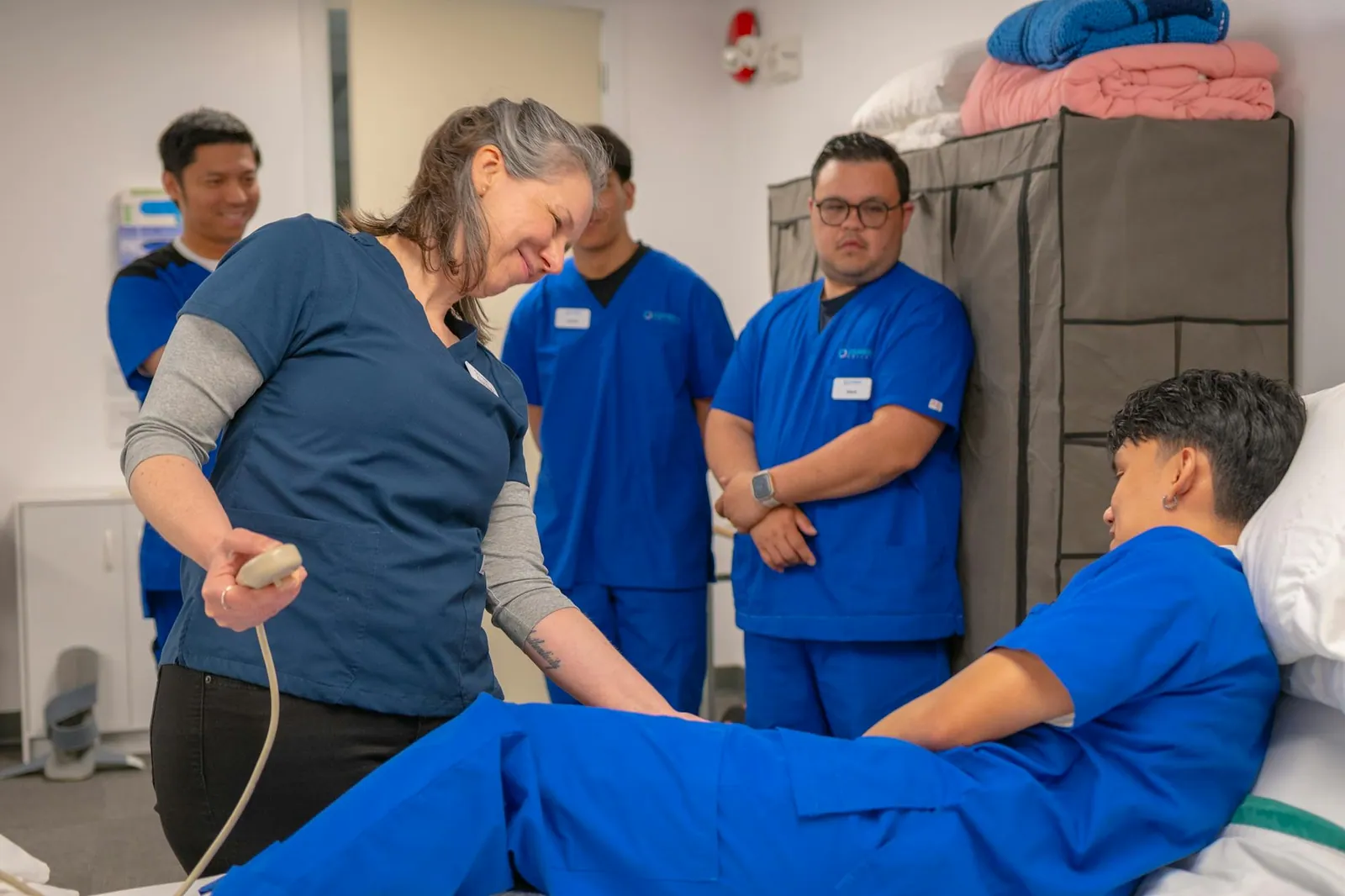 A small group of care workers in a hands-on training session, working together with their instructor.